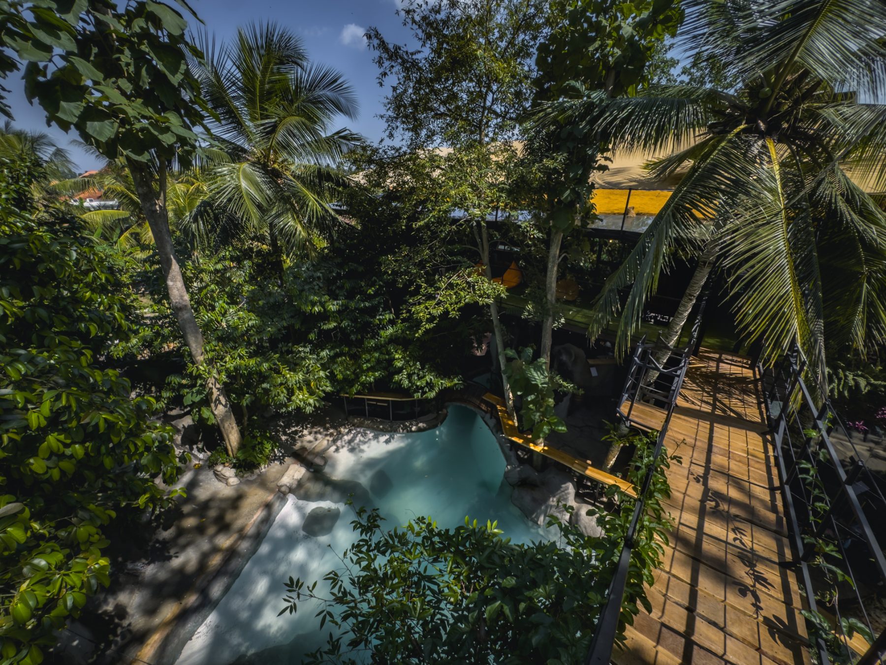 The pool seen from above with the timber bridge to the yoga and pilates studios